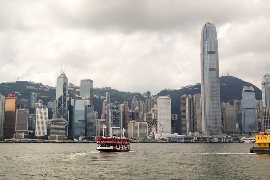 Ferry all'interno della baia di Hong Kong con skyline dei grattacieli